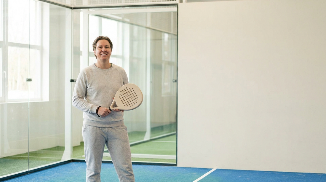 Lächelnder Einsteiger mit Padelschläger auf dem Court