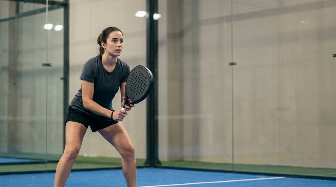 Allround-Padelspieler in ausgewogener Bereitschaftshaltung