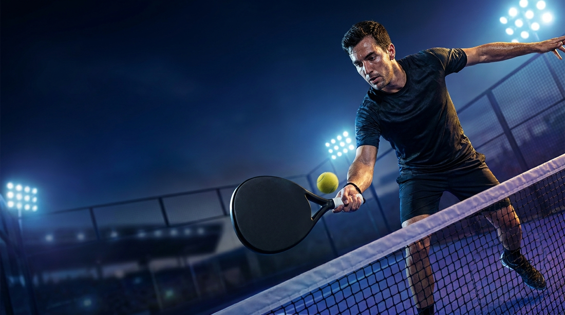 Fortgeschrittener Padelspieler beim druckvollen Volley am Netz